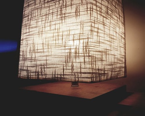 Close-up of a wooden table lamp emitting warm ambient yellow light inside a cozy relaxation room